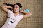 Young woman listening to music while lying down