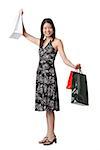 Young woman carrying shopping bags, arms outstretched