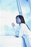 Woman leaning on ledge, looking through window