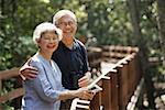 Mature couple side by side, smiling, looking at camera