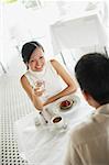 Couple at cafe, woman holding glass of water