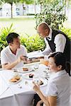 Couple in restaurant, man handing payment to waiter