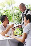 Couple in restaurant, making payment to waiter