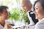 Woman looking away, man paying with credit card bill in the background