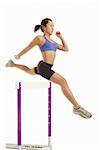 Woman jumping over hurdle