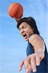 Man holding basketball in the air mouth open
