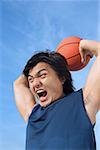 Man holding basketball, shouting