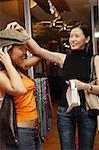 Amis dans la boutique d'accessoires, essayer des chapeaux