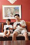 Father and son in living room, playing video game