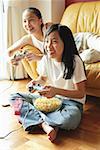 Two sisters in living room, playing video games