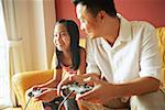 Father and daughter sitting side by side playing video games