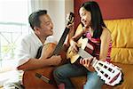 Father and daughter holding guitars