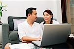 Couple in living room, with laptop