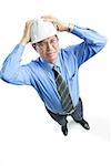 Man wearing hardhat frowning, hands on head