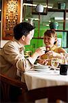 Couple toasting with wine glasses in restaurant