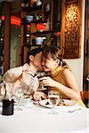 Couple dans un restaurant chinois, griller avec verres à vin, homme femme baiser sur la joue