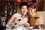 Couple in restaurant, smiling at camera