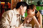 Couple in restaurant, sitting face to face, man holding woman's hand