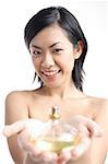 Woman holding perfume bottle, focus on the background