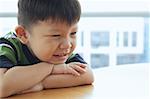 Young boy looking away, leaning on arms