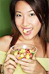 Woman eating candy and holding candy bowl