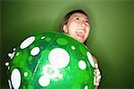 Woman holding inflatable ball, mouth open