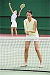 Two women playing a game of tennis