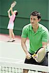Couple playing tennis, mixed doubles