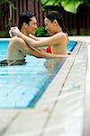 Couple in swimming pool, embracing