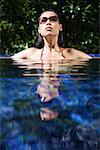 Woman sitting in swimming pool, head above water