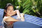 Woman in swimming pool, smiling at camera