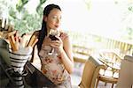 Woman sitting at bar counter, drinking wine, looking away