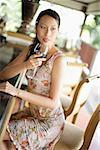 Woman sitting at bar counter, holding wine glass