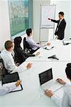 Businessman giving presentation, pointing at whiteboard