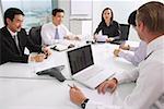 Executives sitting around conference table, having a meeting