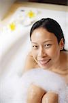Woman in bathtub, smiling at camera