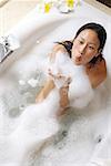 Femme jouissant de bain moussant, savon de soufflage