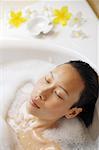 Woman in bathtub, eyes closed, head shot