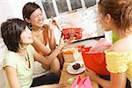 Young women at home, celebrating birthday, opening gifts