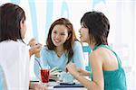 Drei junge Frauen im Cafe, im Gespräch