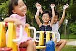 Three girls on a seesaw, arms outstretched