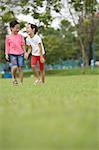 Two girls walking in park, laughing