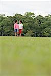 Two girls on grass, walking, holding hands