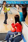 Women in bowling alley, cheering friend on