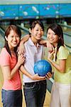 Drei Frauen am Bowlingcenter, nebeneinander stehen, in die Kamera Lächeln