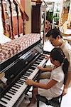 Père et fille jouer du piano