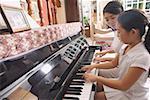 Mother and daughter playing the piano