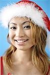 Woman wearing Santa hat, smiling at camera