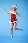 Woman in Santa hat and red dress, jumping