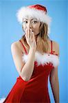 Woman wearing Santa hat and red dress, hand covering mouth